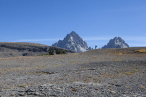 A hiker is sillouetted against the Teton Range while hiking the